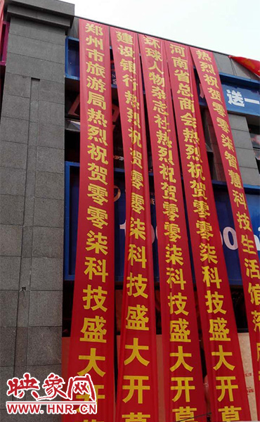路邊一棟樓上懸掛著二三十條紅色條幅，全部是祝賀一家公司開業(yè)的。