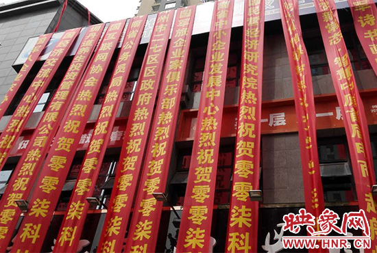 路邊一棟樓上懸掛著二三十條紅色條幅，全部是祝賀一家公司開業(yè)的。