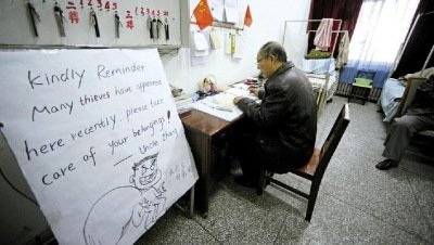 張大爺在門衛(wèi)室里工作，旁邊是紅爆網(wǎng)絡(luò)的溫馨提示牌記者