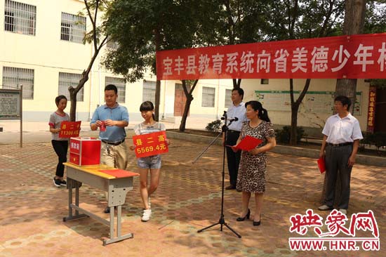 寶豐縣教育系統(tǒng)全體人員在石橋鎮(zhèn)中學為“美德少年”楊冠明同學捐款。