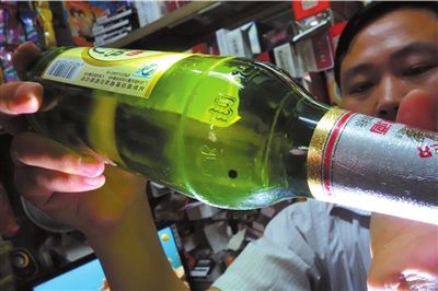 這瓶未開(kāi)封的燕京啤酒內(nèi)有一顆黑色懸浮物。京華時(shí)報(bào)記者 徐曉帆 攝