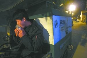 快遞哥抽空吃兩口東西。記者 李剛 攝