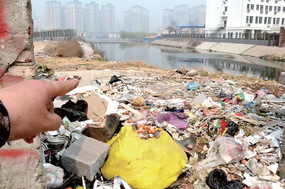 金水河長江路橋下河水發(fā)臭，水邊堆放眾多垃圾