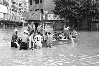 18日，廣東省清遠市陽山縣縣城,消防官兵合力推動沖鋒舟，轉(zhuǎn)移被困學(xué)生。新華社發(fā)