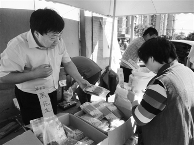 昨日，河南企業(yè)家劉春喜在京“練攤”，為顧客挑選綠豆。新京報記者 張玉學 攝