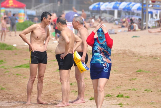 2013年7月3日，山東青島青島高溫來襲，“青島大媽”不懼滸苔，戴著“強盜面具”出現(xiàn)在海水浴場消暑降