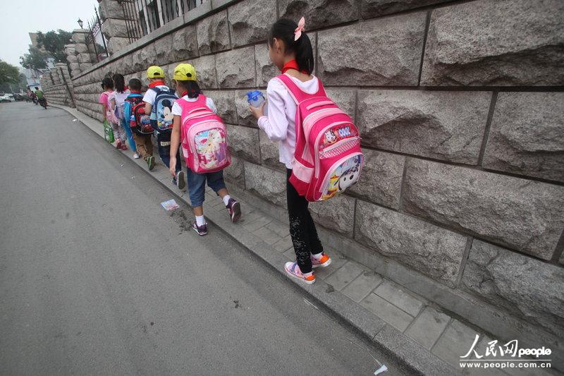 2013年09月11日，濟(jì)南運(yùn)署街上，小學(xué)生走史上“最窄人行道”上學(xué)。