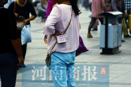 火車站廣場(chǎng)，一女子拿著寫有不同房型價(jià)位的卡片在拉客，不少市民抱怨，受過此類“騷擾”