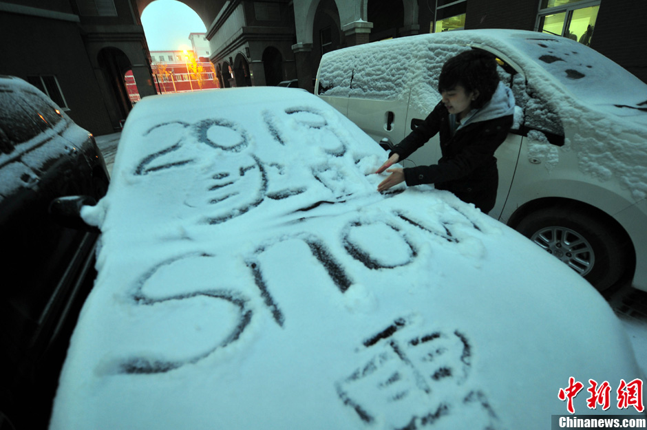 11月18日，行人在車輛的積雪上涂鴉。
