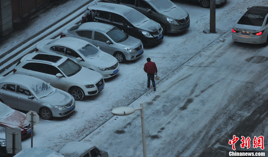 11月18日，行人在沈陽街頭的積雪中穿行。