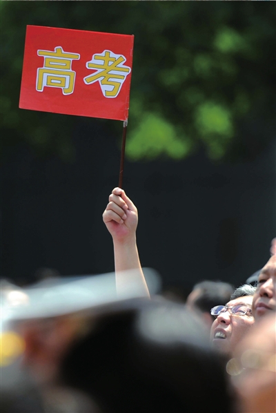 6月7日，在東直門考點(diǎn)外，一名家長(zhǎng)手舉高考的小旗子迎接孩子。資料圖片本報(bào)記者王苡萱攝