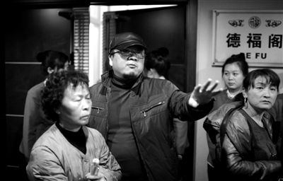昨日，在河北香河天下第一城，相關(guān)負責人（左二）走出會議室與參加演出的老人們溝通。