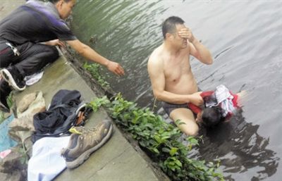 網(wǎng)友貼出民警張光聰一出河水就睜不開眼，用手抹去臉上臟水的照片。