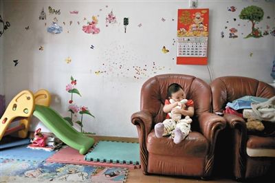 6月14日，未婚媽媽于軍的家里。女兒悅悅抱著兔子玩偶，在聽媽媽手機上的兒歌，這個4歲女孩喜歡兔子。