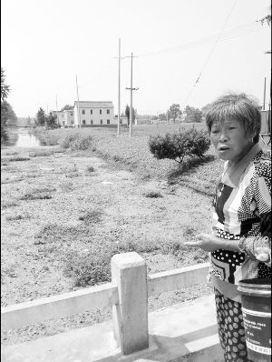 河里長(zhǎng)滿浮萍漂著垃圾，村民有時(shí)不得已用河水應(yīng)急