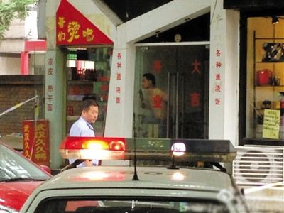 闖入面館的持刀男子與趕來的民警隔著玻璃門對峙，后店內(nèi)一名女童被其劫持。網(wǎng)友供圖