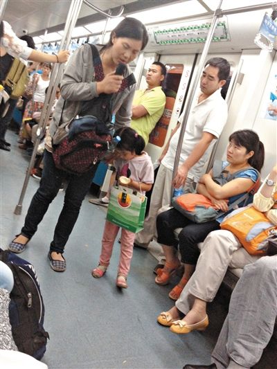 6月27日，舒馨帶一女孩在地鐵十號線行乞。她因被疑帶多個(gè)不同小孩乞討被警方搜尋。新京報(bào)記者 申志民 攝