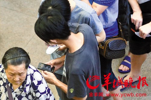 排隊的“黃?！备魇謭?zhí)一疊白紙，上面寫好了要掛號的人的信息，包括姓名、電話、要掛的科室等。穿黑白花紋衣服的老婆婆正在排隊掛號