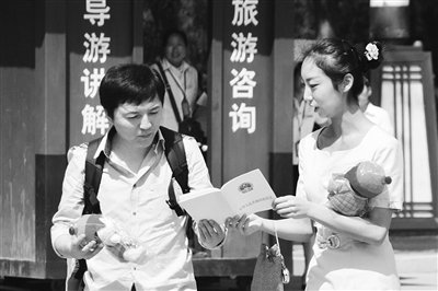 9月13日，西安臨潼華清池景區(qū)服務(wù)人員向游客介紹《旅游法》。