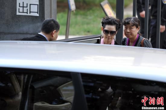 圖為宣判結(jié)束后夢鴿面無表情走出海淀法院，乘車離開。
