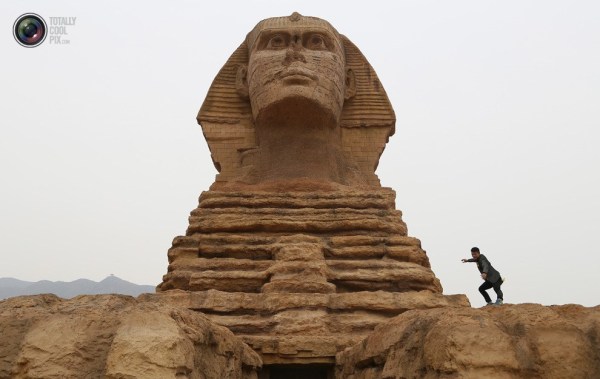 石家莊郊外，一名男子與山寨版獅身人面像合影留念。