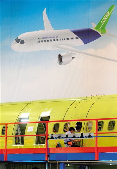 昨日，中國商飛總裝制造中心技術人員對接C919首架機的機體。新華社記者 丁汀 攝