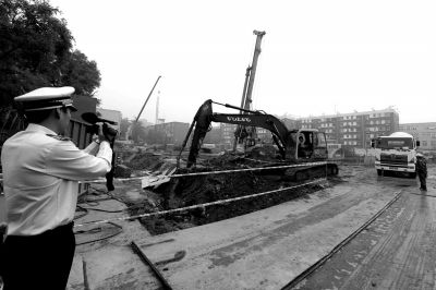 學(xué)院南路一科研樓項目有3臺挖掘機違規(guī)進行土方作業(yè)，被城管隊員當場責令停工。京華時報記者歐陽曉菲攝