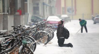 小伙子跪在樓前，一直抬頭看著樓上。 孫立國(guó)/攝