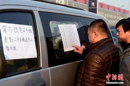 1月23日，北京亞運(yùn)村汽車交易市場中拓拍賣停車場上人頭攢動(dòng)，市民查看拍賣車輛信息。