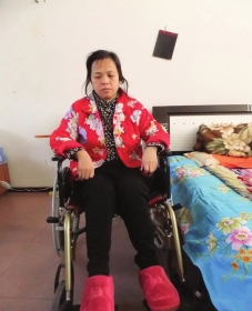 陳慶霞坐在輪椅上。她現(xiàn)在下身癱瘓，疾病纏身，生活不能自理。