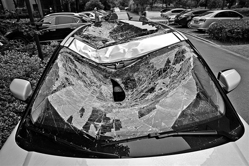 越野車車蓋以及前擋風玻璃被砸得凹陷進去。見習記者姚卡/攝