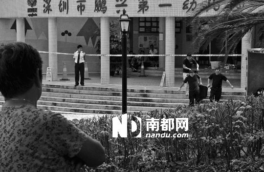 →7月19日，鵬興花園第一幼兒園門前，民警在現(xiàn)場(chǎng)進(jìn)行完勘查取證后，園長(zhǎng)和保安的尸體被運(yùn)走。南都記者 徐文閣 攝