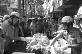 7月11日，瀏陽市北正中路，執(zhí)法人員暫扣張海的水果。這是瀏陽市城管局拍攝的執(zhí)法現(xiàn)場(chǎng)圖。