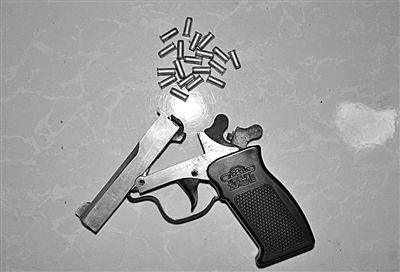 警方從搶劫嫌疑人處起獲的贓款和發(fā)令槍、子彈。警方供圖