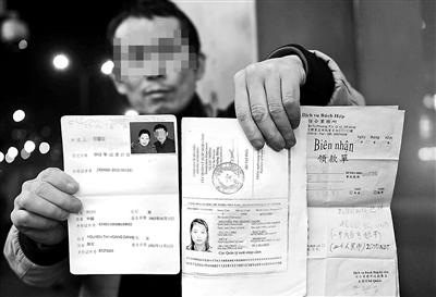賀先生向記者出示他與越南妻子的結(jié)婚證、新娘護照和部分相關(guān)交費單據(jù) 攝影/本報記者　袁藝