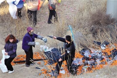 1月4日，連霍高速蘭州市榆中縣和平鎮(zhèn)段，一名警察舉著槍驅(qū)散哄搶橘子的村民。圖/CFP