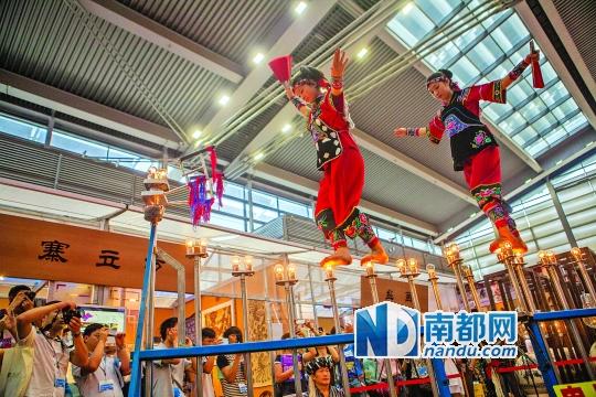 2號(hào)展館，苗族姑娘表演踩燈泡絕技《電光玫瑰》，赤腳踩上40瓦的燈泡并做出高難度動(dòng)作。 南都記者 霍健斌 攝