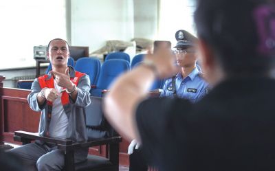 張志國在法庭上用手語回答提問。記者 蒲東峰攝