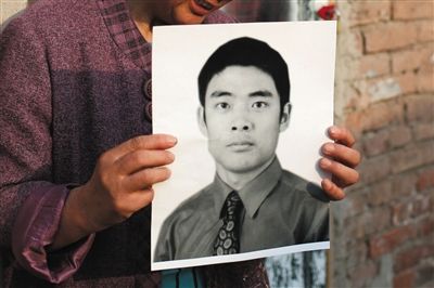 5月19日，朝陽(yáng)北路，母親捧著張東文的遺像。新京報(bào)記者 侯少卿 攝