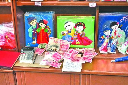 　　2012年6月21日，在朝鮮羅先特別市的一家商店里，柜臺上散落著一些人民幣。在朝鮮，人民幣比本國