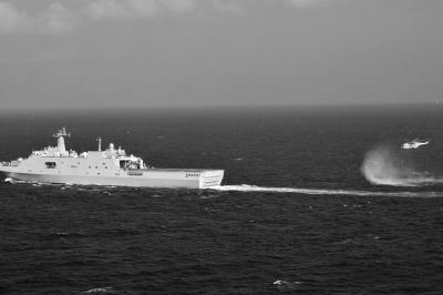 11日，抵達馬航飛機失聯(lián)海區(qū)的海軍井岡山艦與艦載直升機協(xié)同展開立體搜救行動。新華社發(fā)