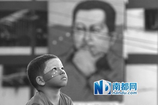 3月5日，一名委內(nèi)瑞拉兒童仰望天空，他身后是查韋斯的陵墓。