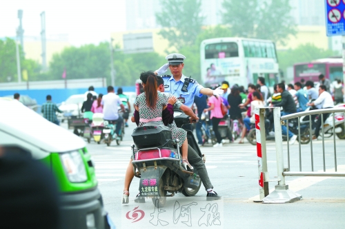 鄭州市交巡警五大隊民警楊華民正帶領(lǐng)他的同事在路口執(zhí)勤