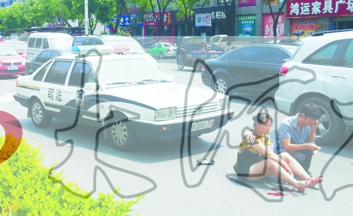 事故發(fā)生后，警車司機(jī)（右）下車查看傷者并撥打120，倆“領(lǐng)導(dǎo)”穩(wěn)坐車內(nèi)引發(fā)圍觀者不滿。