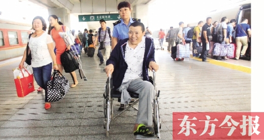 李剛手術(shù)后歸來，在車站工作人員幫助下走出鄭州火車站站臺  東方今報首席記者 張曉冬 攝