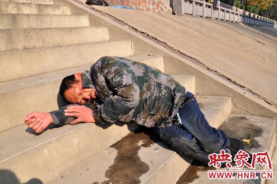 這名男子的衣服以及褲子全濕透了，水從衣褲里流出來，嘴里散發(fā)著濃烈的酒氣。