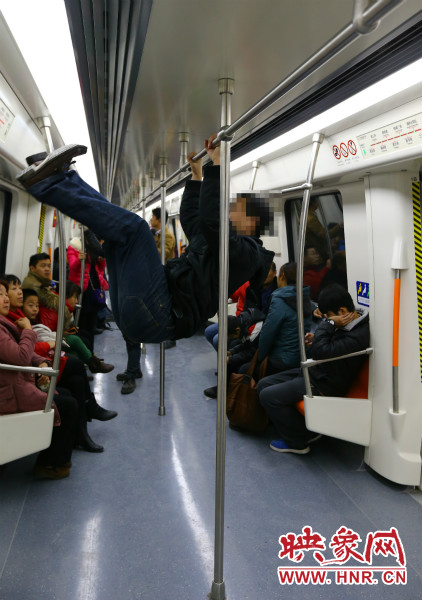 地鐵試乘日，一男子在車廂內(nèi)攀爬扶手自娛自樂