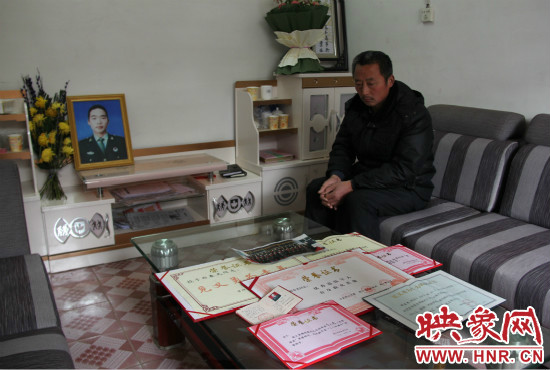救火英雄鄭春光的父親和兒子獲得榮譽(yù)證書。