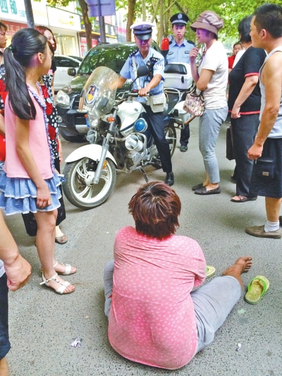 在鄭州優(yōu)勝南路東三街交叉口向東100米處，一名短發(fā)中年女子平躺在路南快車道上，身旁還有一只掉落的拖鞋