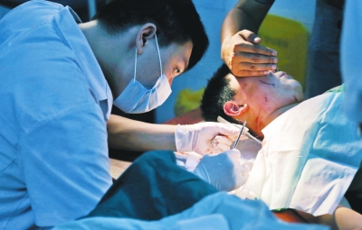 孩子身上有7道傷痕，其中兩道需要縫合，其他的均為擦傷，醫(yī)生正對(duì)他施治。